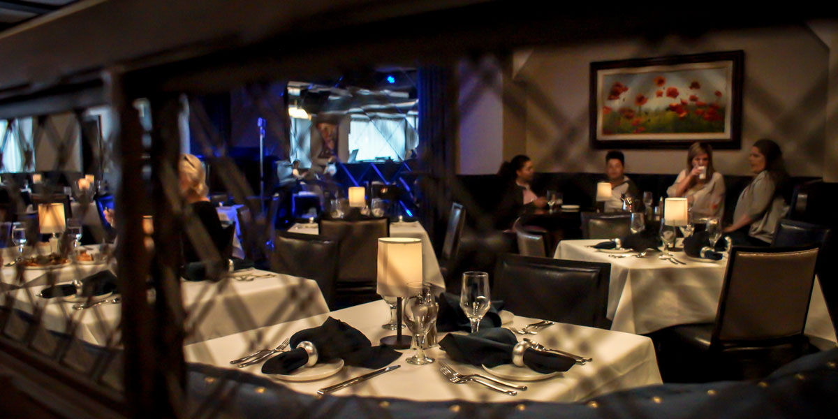 The warmly lit Caucus Club dining room set with white tablecloths