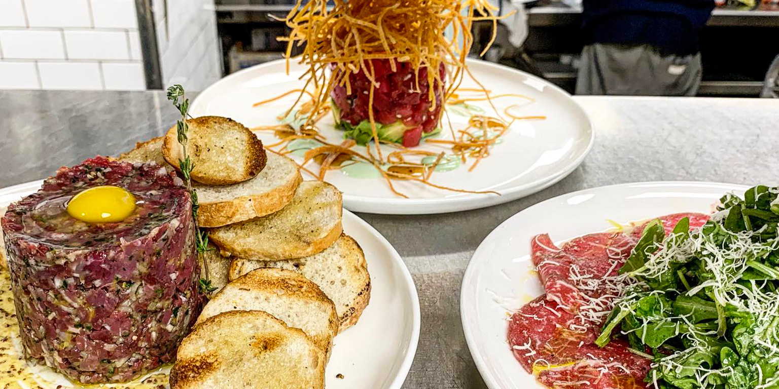 Steak tartare, tuna tartare, and carpaccio prepared at the Caucus Club